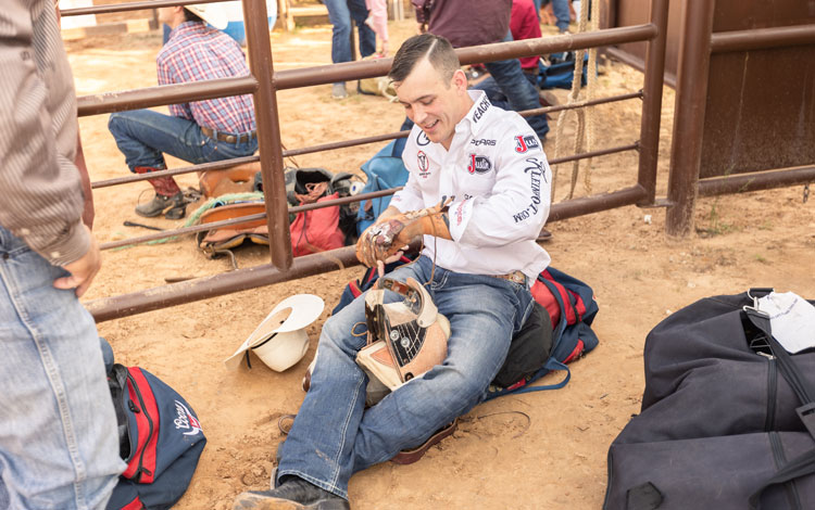 Bareback Rider, Tim O'Connell, putting rosin on his riding glove and warming up with his bareback riggin' before competing at a rodeo.